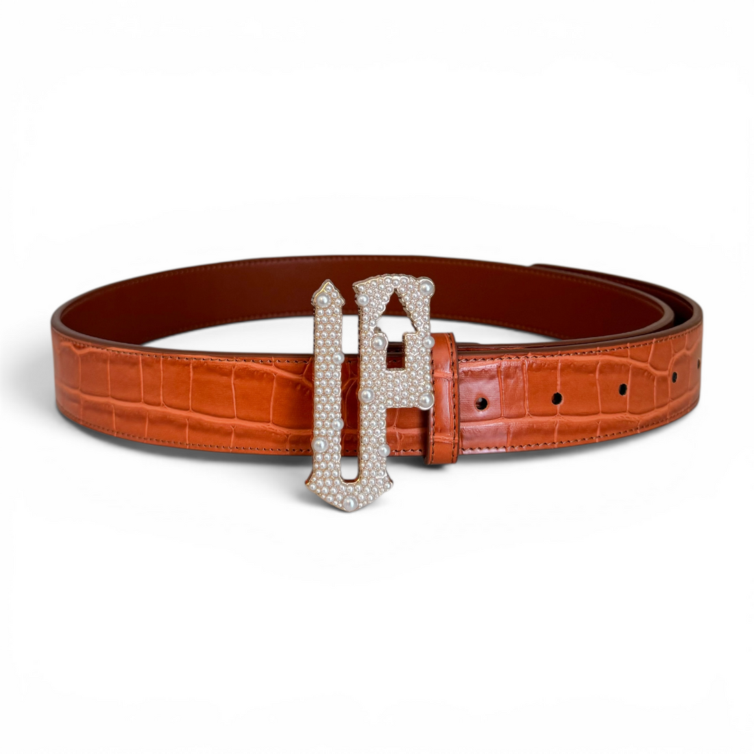 Orange belt with a decorative silver buckle on a white background