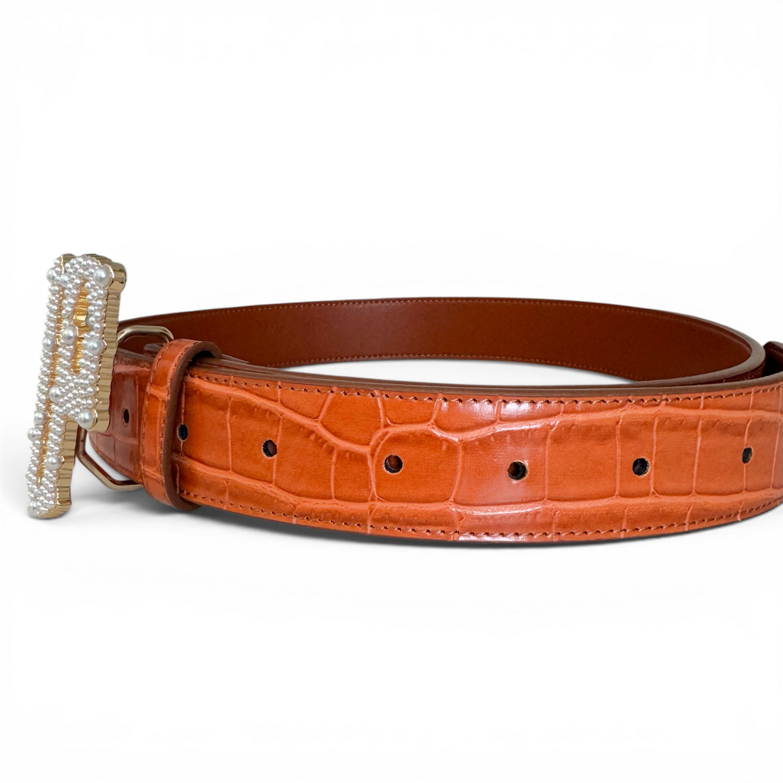 Orange leather belt with a pearl decorative buckle on a white background