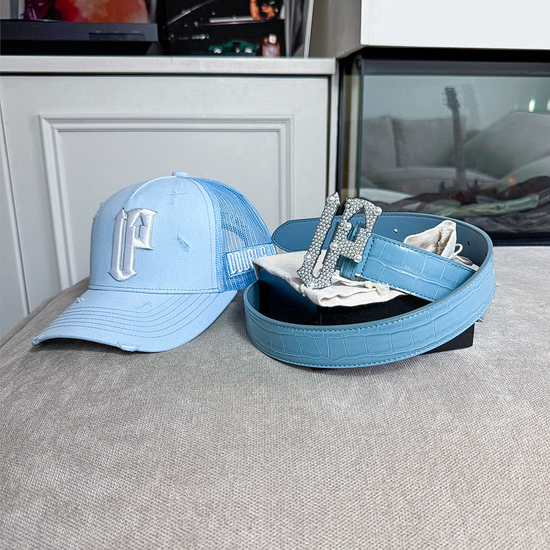Blue cap and belt with decorative buckle on a textured surface